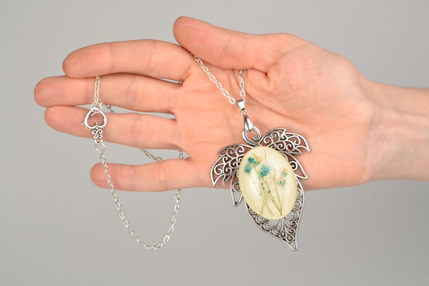 Handmade lacy leaf-shaped pendant with natural flowers in epoxy resin on chain photo 2