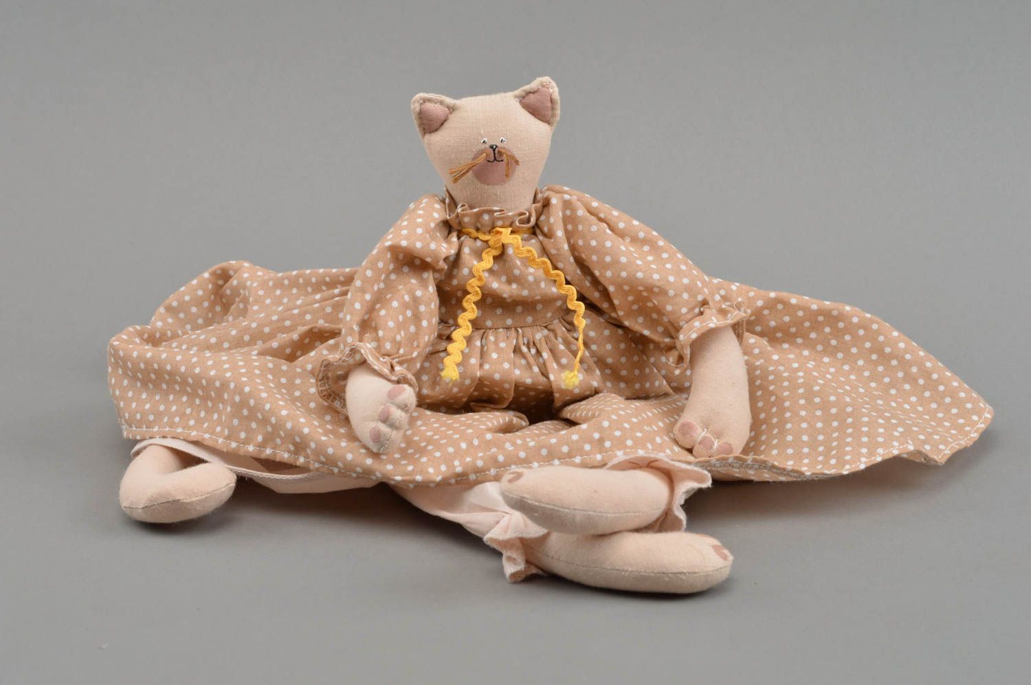 Handgemachtes Spielzeug aus Stoff Katze für Kinder im gepunkteten Kleid  foto 3