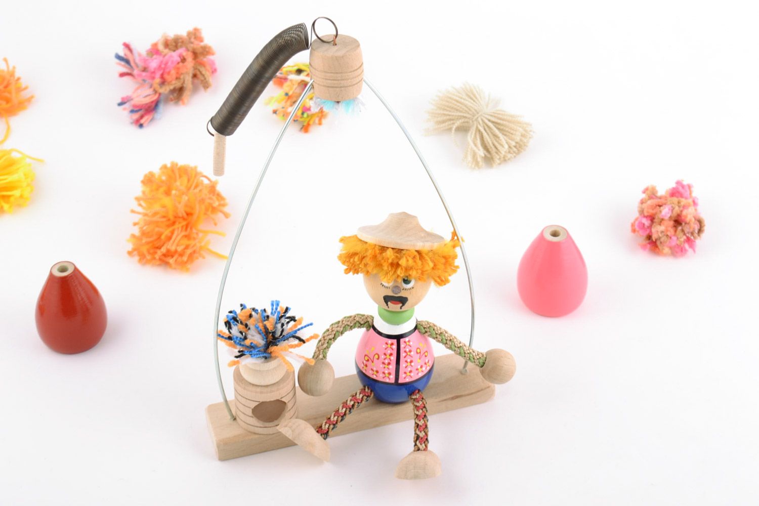 Lustiges bemaltes handmade Spielzeug aus Holz Mann auf der Bank foto 1