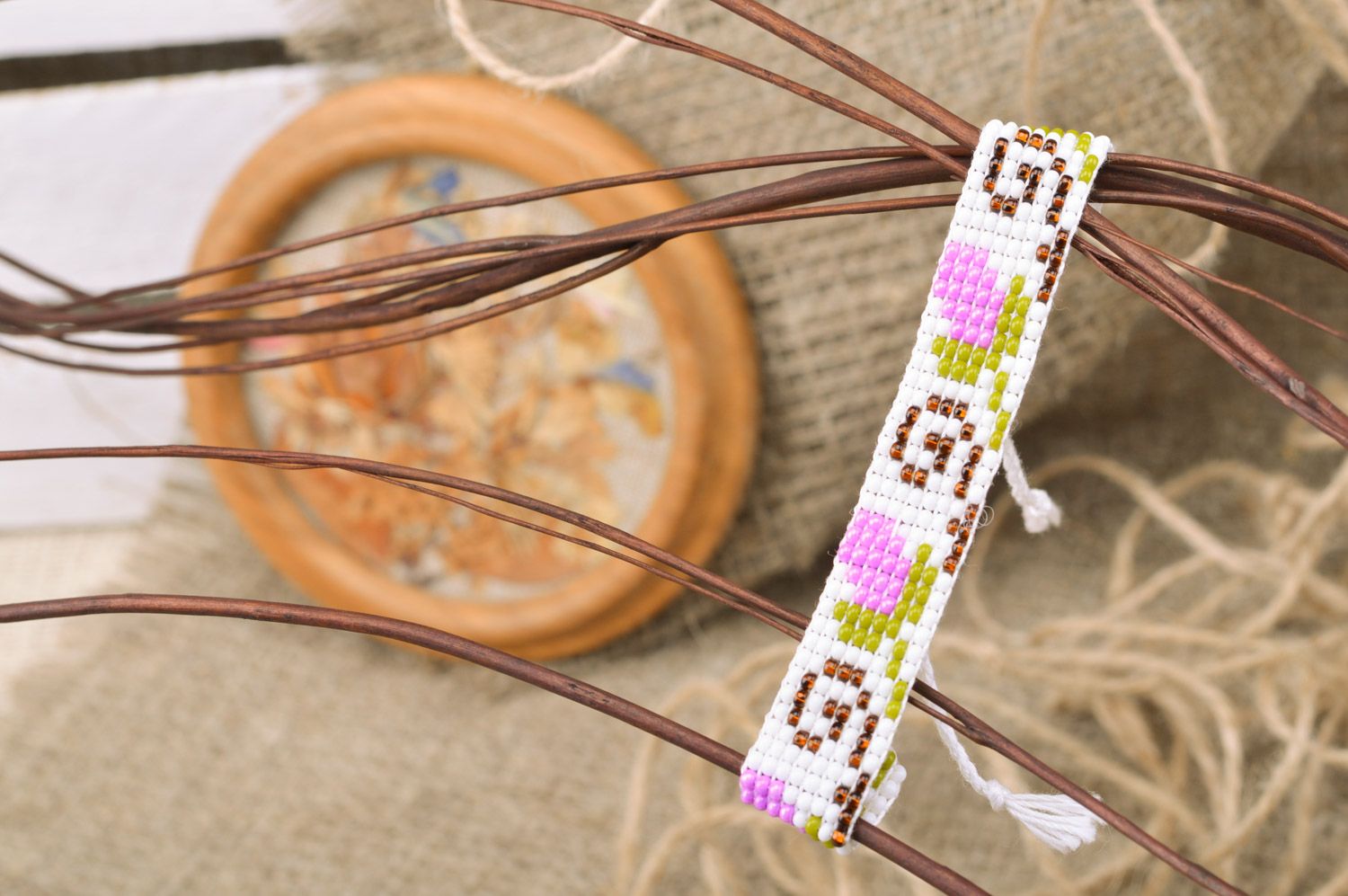 Stylish handmade women's wrist bracelet woven of beads and threads of light color with flower pattern photo 1