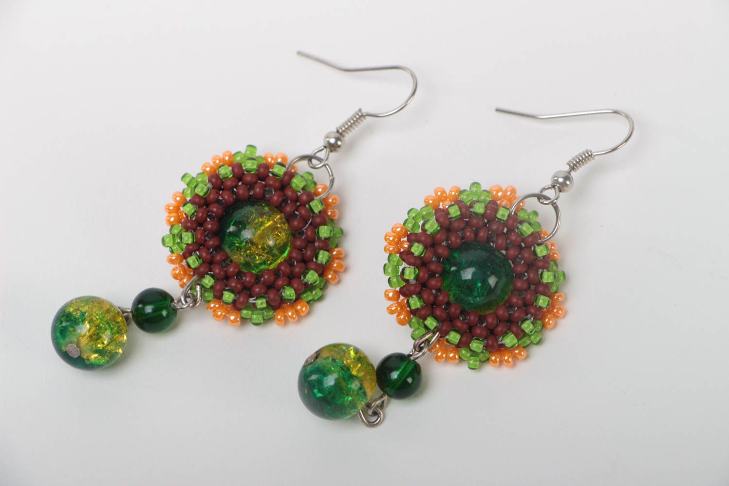 Schöne originelle grüne handgemachte Ohrringe aus Glasperlen und Metall foto 2