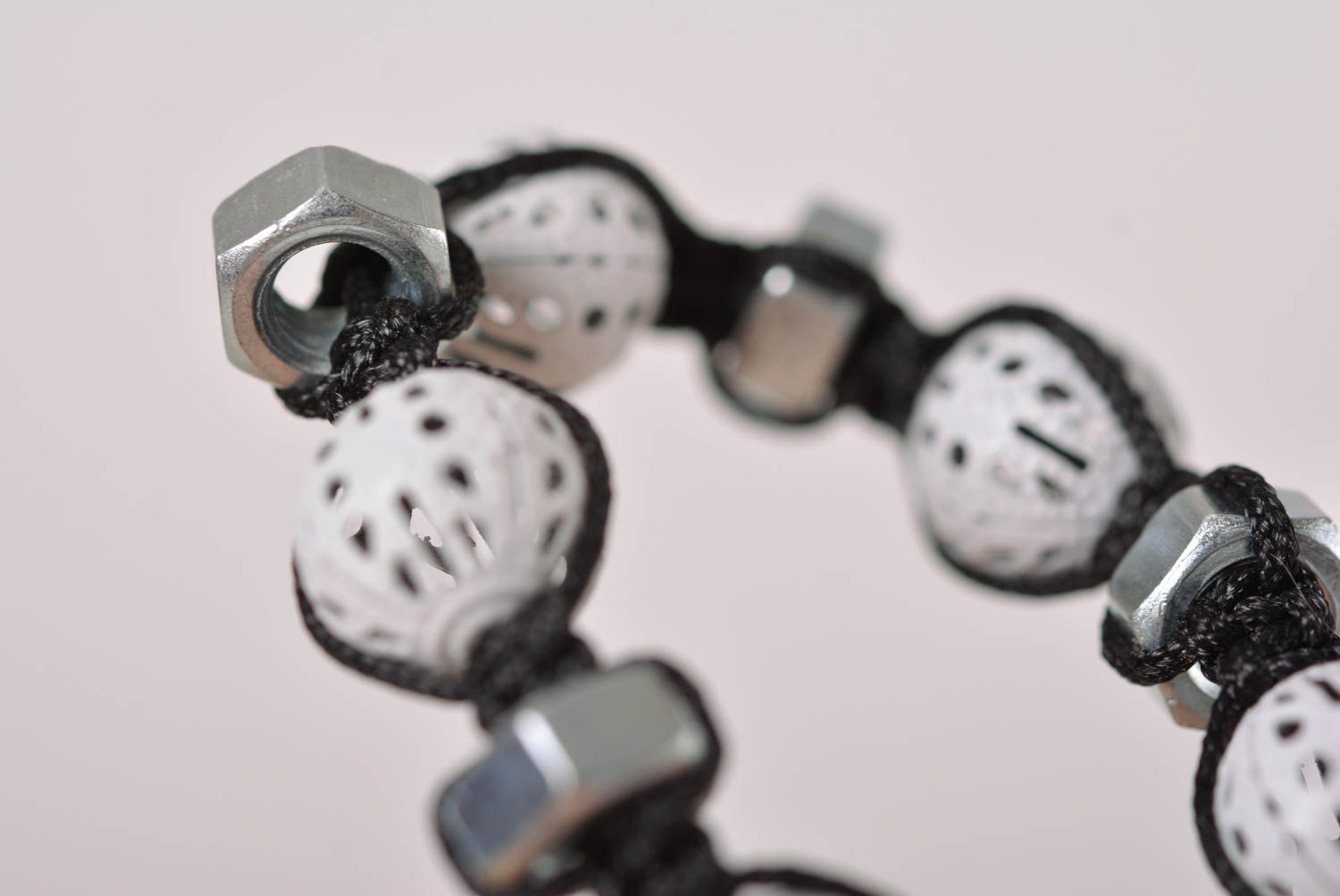 Strand black cord bracelet with white ceramic beads and female metal screws photo 5