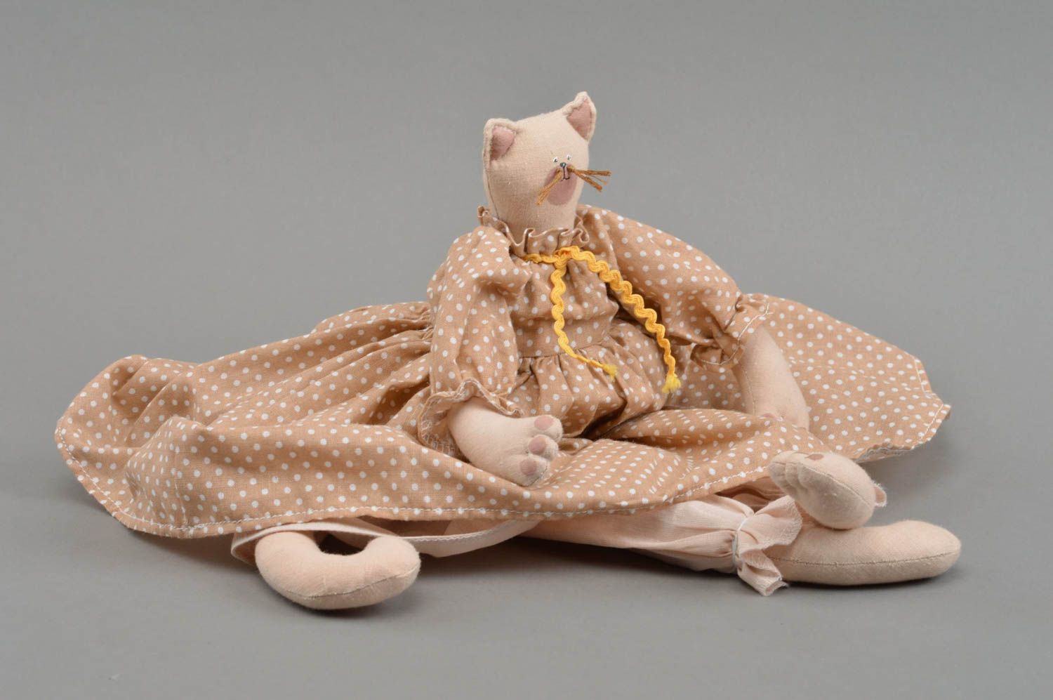 Handgemachtes Spielzeug aus Stoff Katze für Kinder im gepunkteten Kleid  foto 4