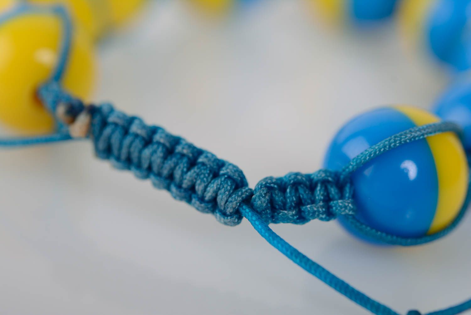 Künstlerisches dünnes buntes Armband aus Plastik und Schnur in Blau und Gelb foto 4