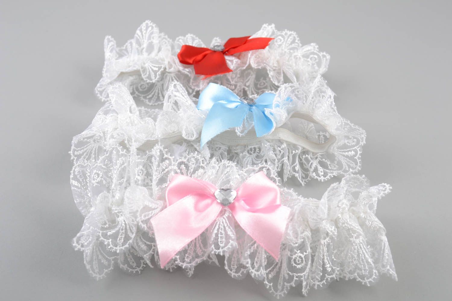 Handmade set of garters 3 pieces made of guipure and satin with colorful bows photo 3