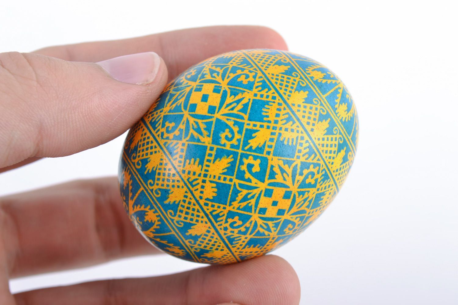 Bright painted handmade Easter egg with rich pattern of yellow and blue colors photo 2