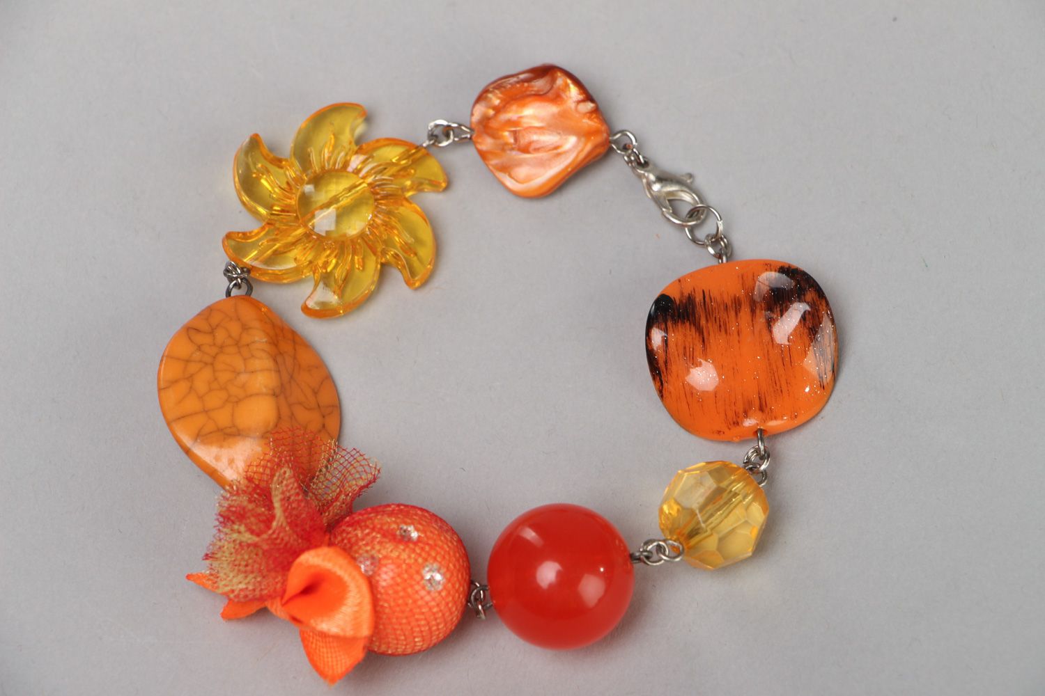 Bright handmade wrist bracelet with orange plastic beads of different shapes photo 1