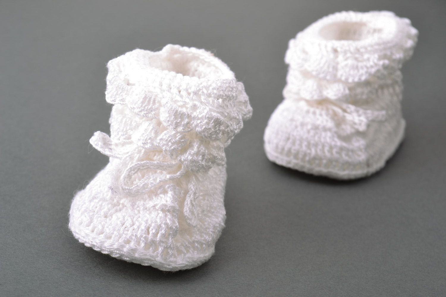 White handmade baby booties knitted of wool and cotton in the shape of shoes photo 5