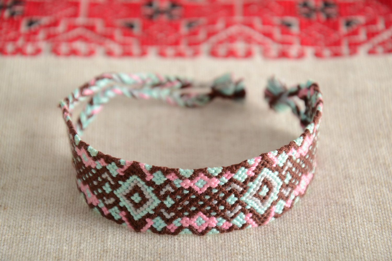 Handmade friendship wrist bracelet woven of threads with colorful ornament photo 1