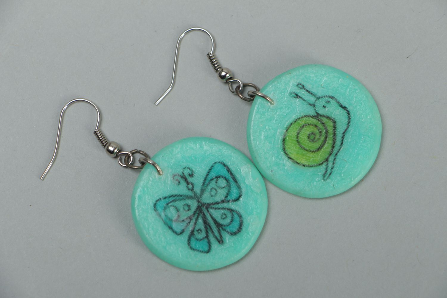 Turquoise plastic earrings with drawing photo 1