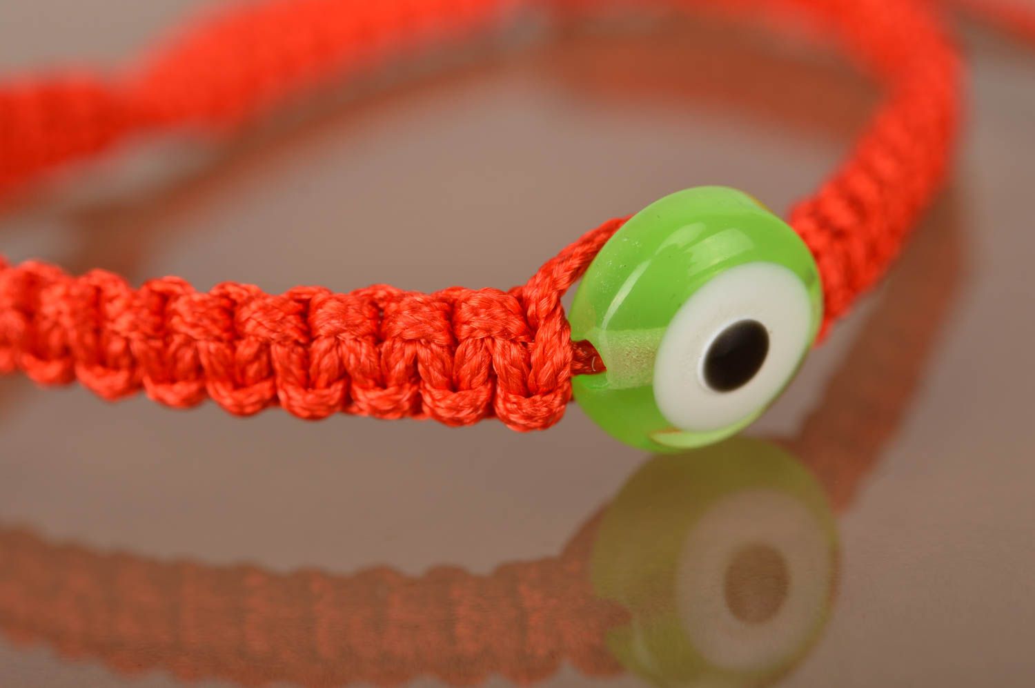 Bracelet fait main pour enfant en lacet ciré rouge tressé fin Œil vert photo 2