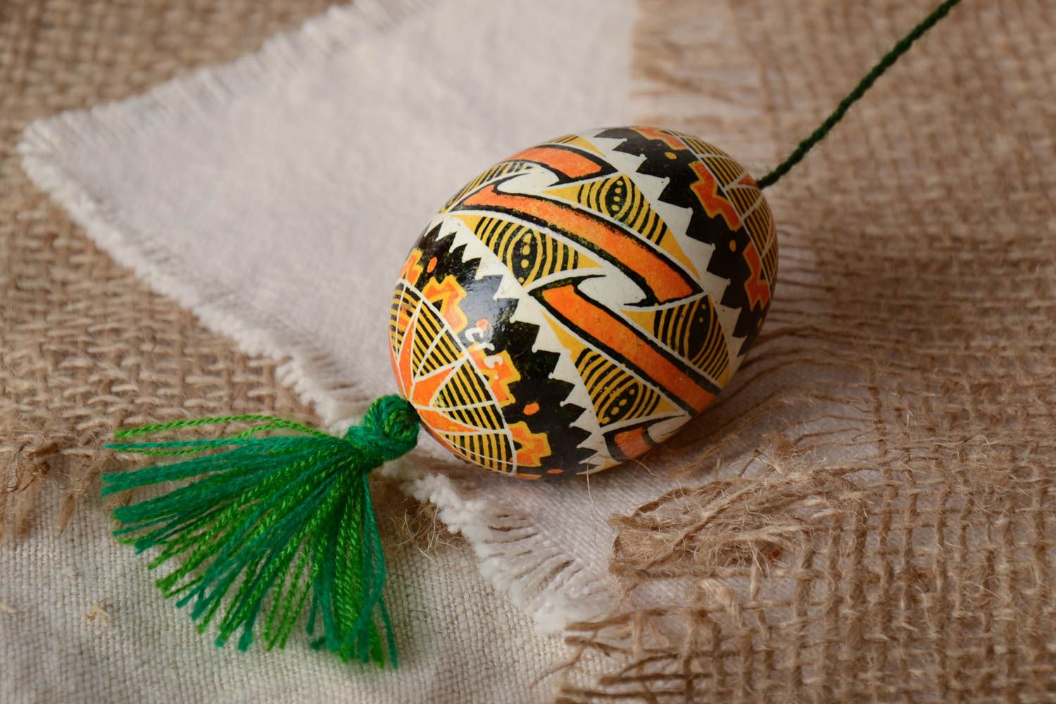 Handmade traditional wax painted colorful Easter egg with green tassel photo 1