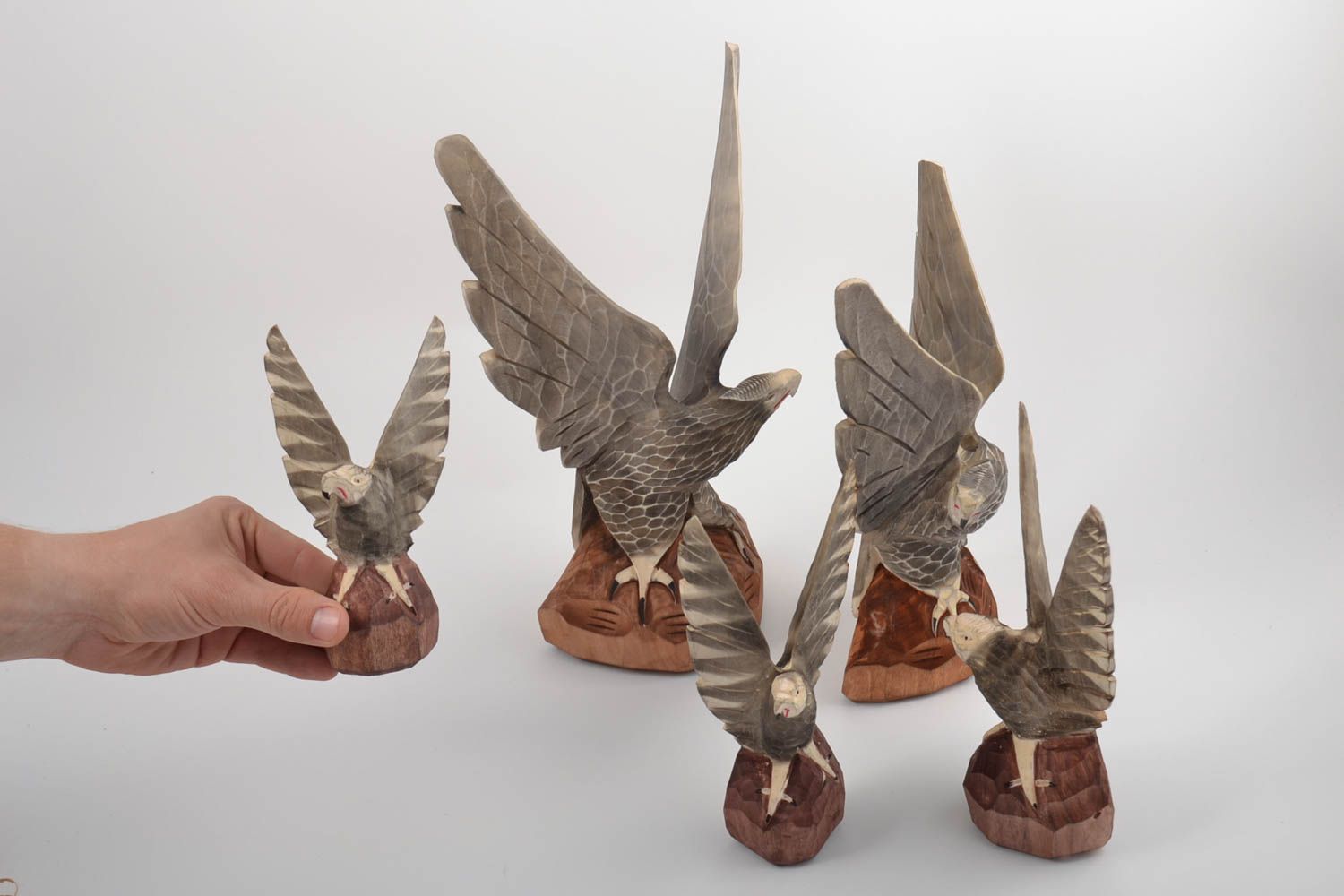 Conjunto de figuras de madera hechos a mano con forma de águilas de diferentes tamaños foto 2