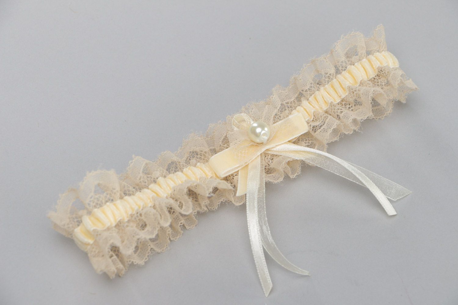 Tender thin lacy wedding bridal garter of champagne color with velor and pearls  photo 2