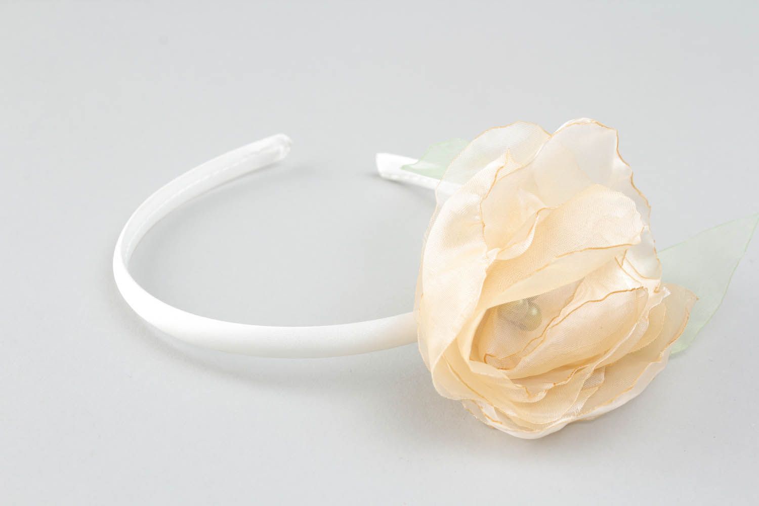 Aro de cabelo decorado com uma flor feita de tecido leve transparente e contas foto 1