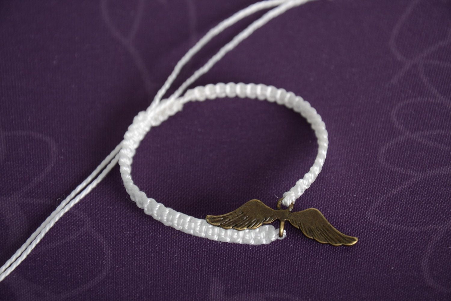 Bracelet cordon blanc tressé de fils en nylon avec pendeloque ailes fait main photo 1
