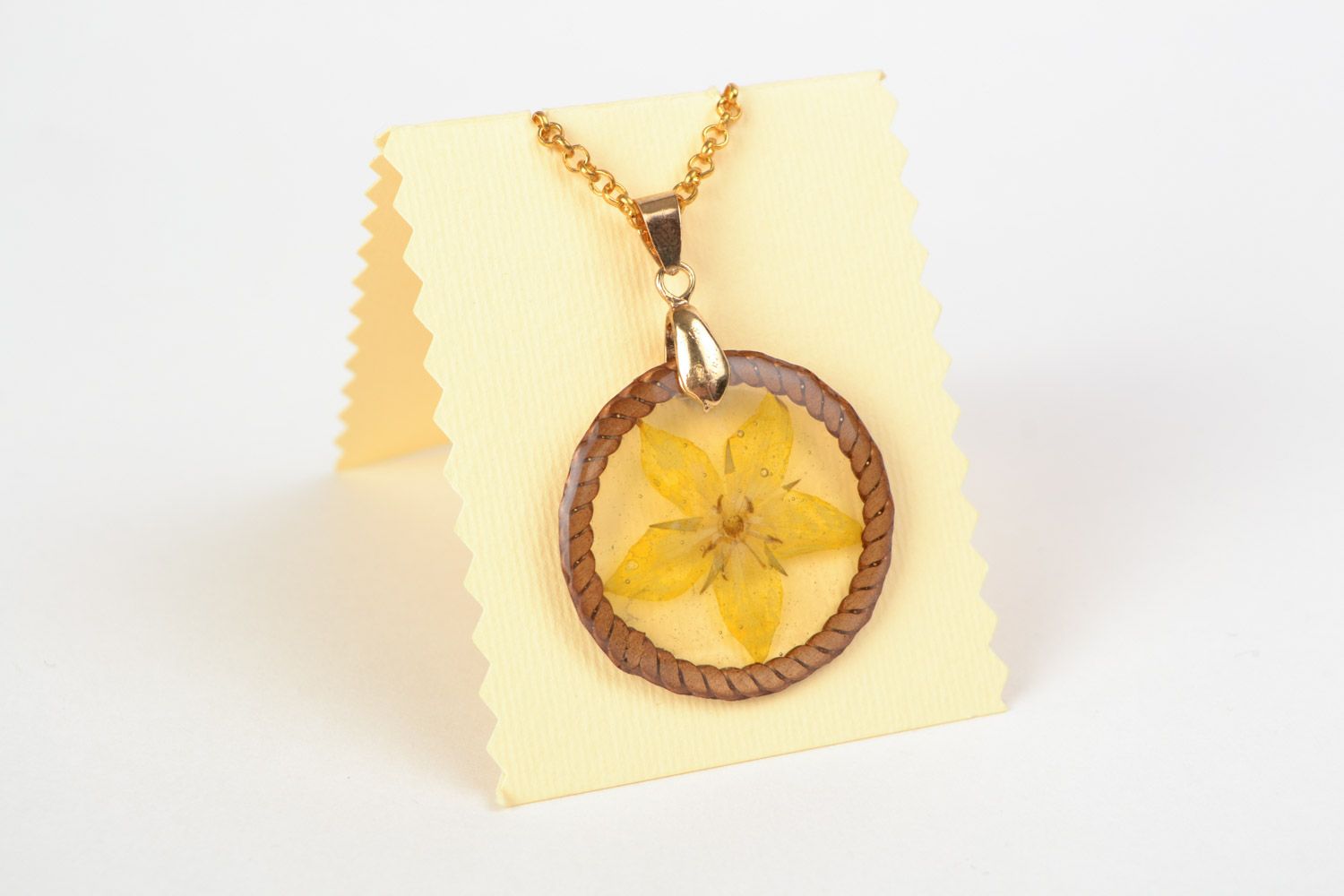 Handmade round pendant with natural dried flower embedded in epoxy resin photo 1