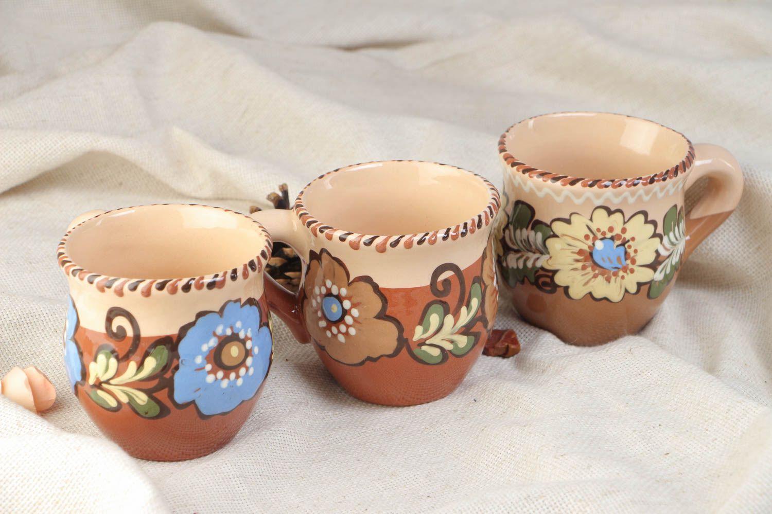 Set of three glazed village-style tea cups with painted flower pattern photo 1