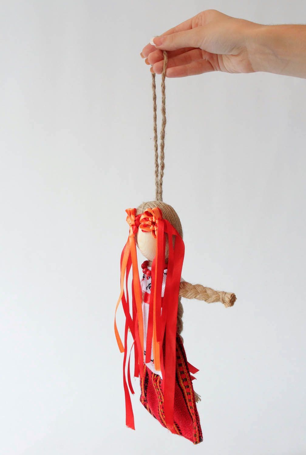 Boneca étnica protectora feita à mão de tecidos naturais de vermelho foto 1