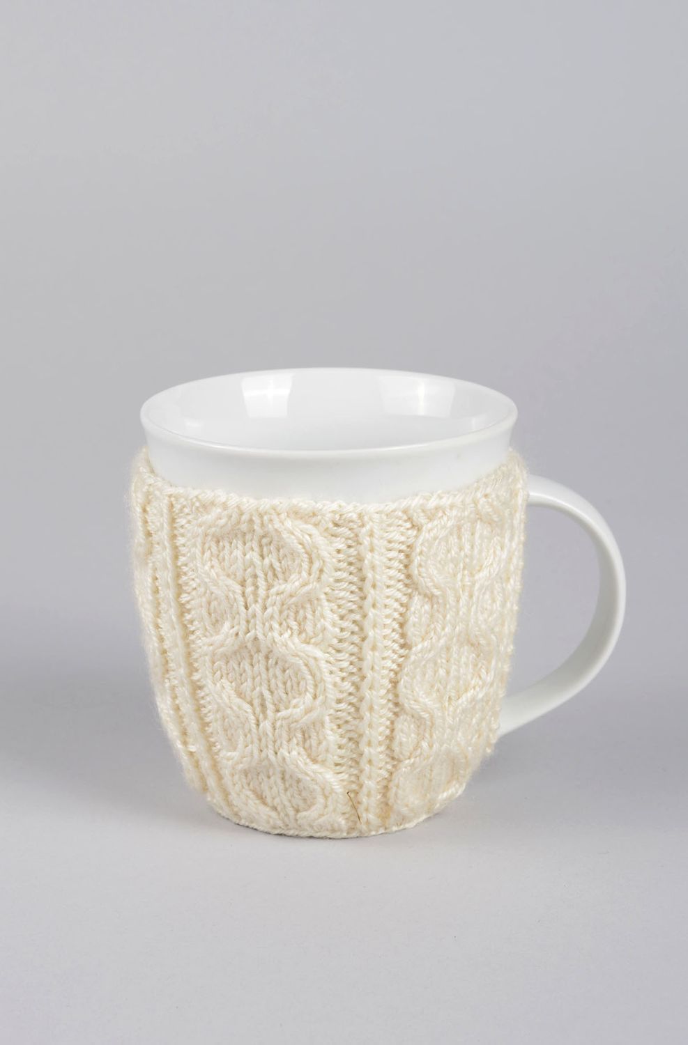 White ceramic porcelain tea or coffee cup with knitted cover with classic pattern photo 1