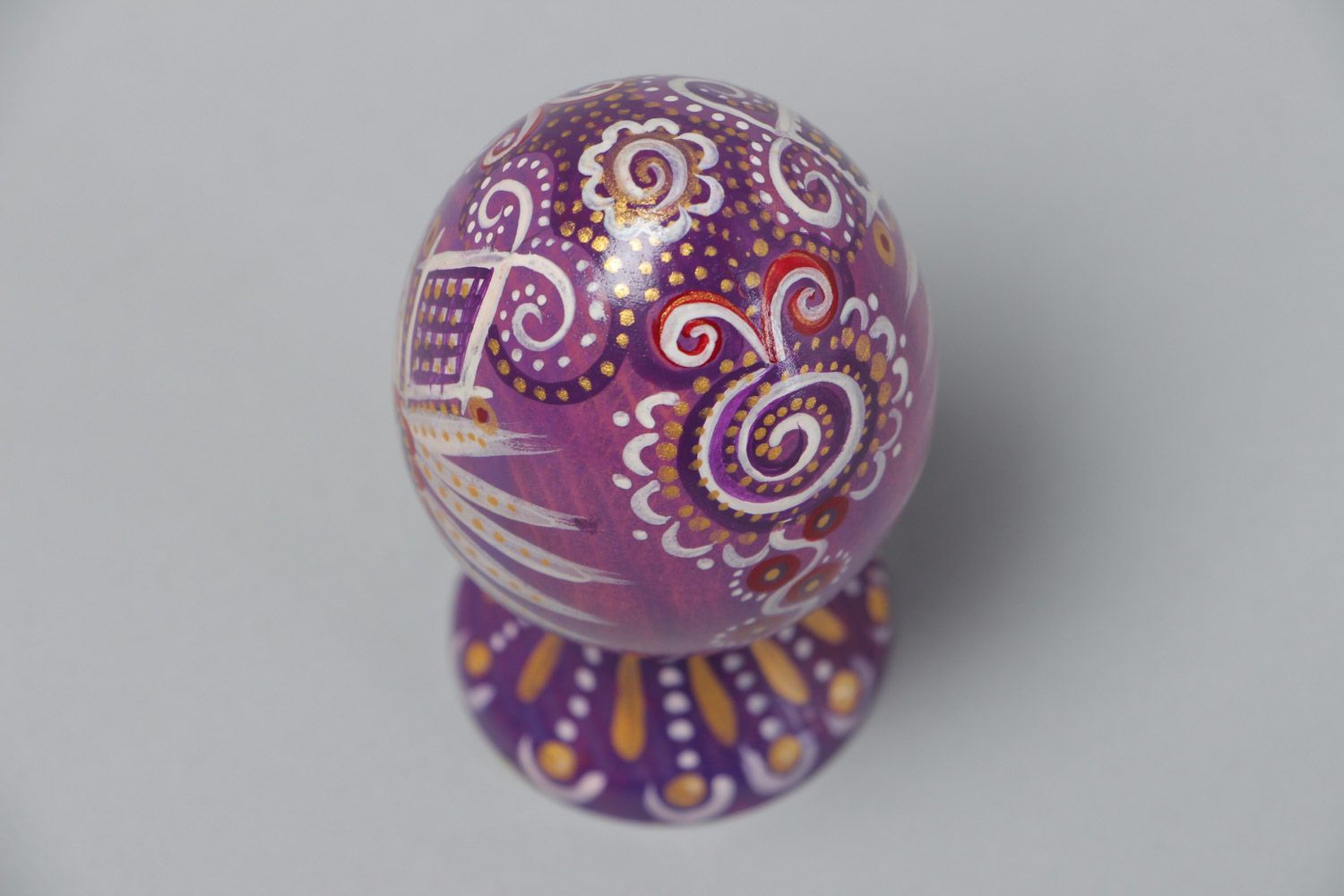 Huevo de Pascua de madera en soporte violeta en estilo étnico artesanal foto 3