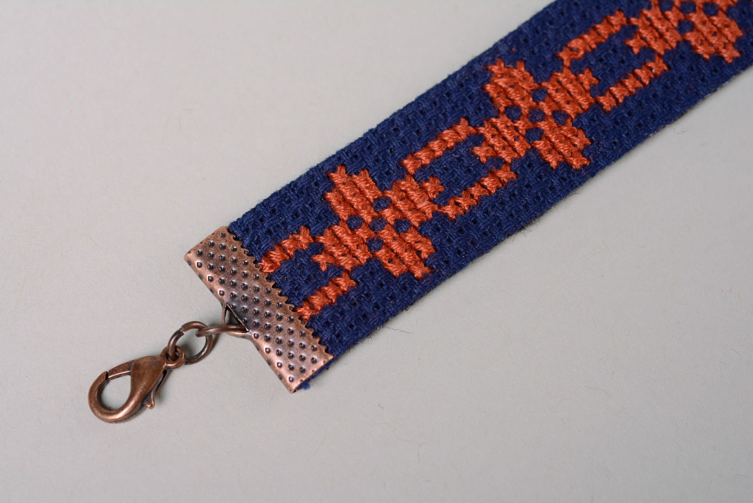 Handmade women's wrist bracelet with ethnic embroidery on dark blue background photo 3