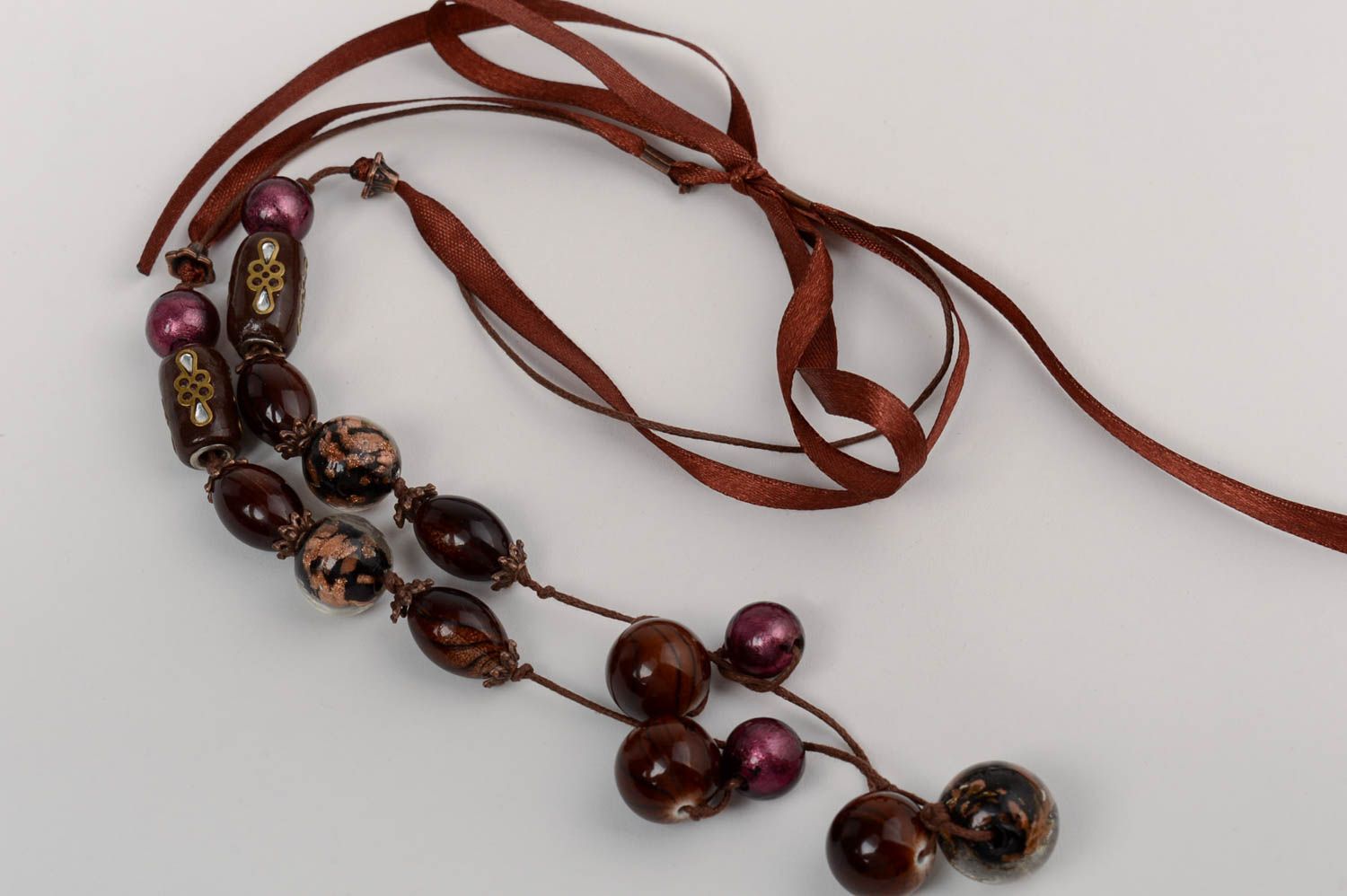 Lange schöne braune handmade Halskette mit Glasperlen auf einem Atlasband foto 5