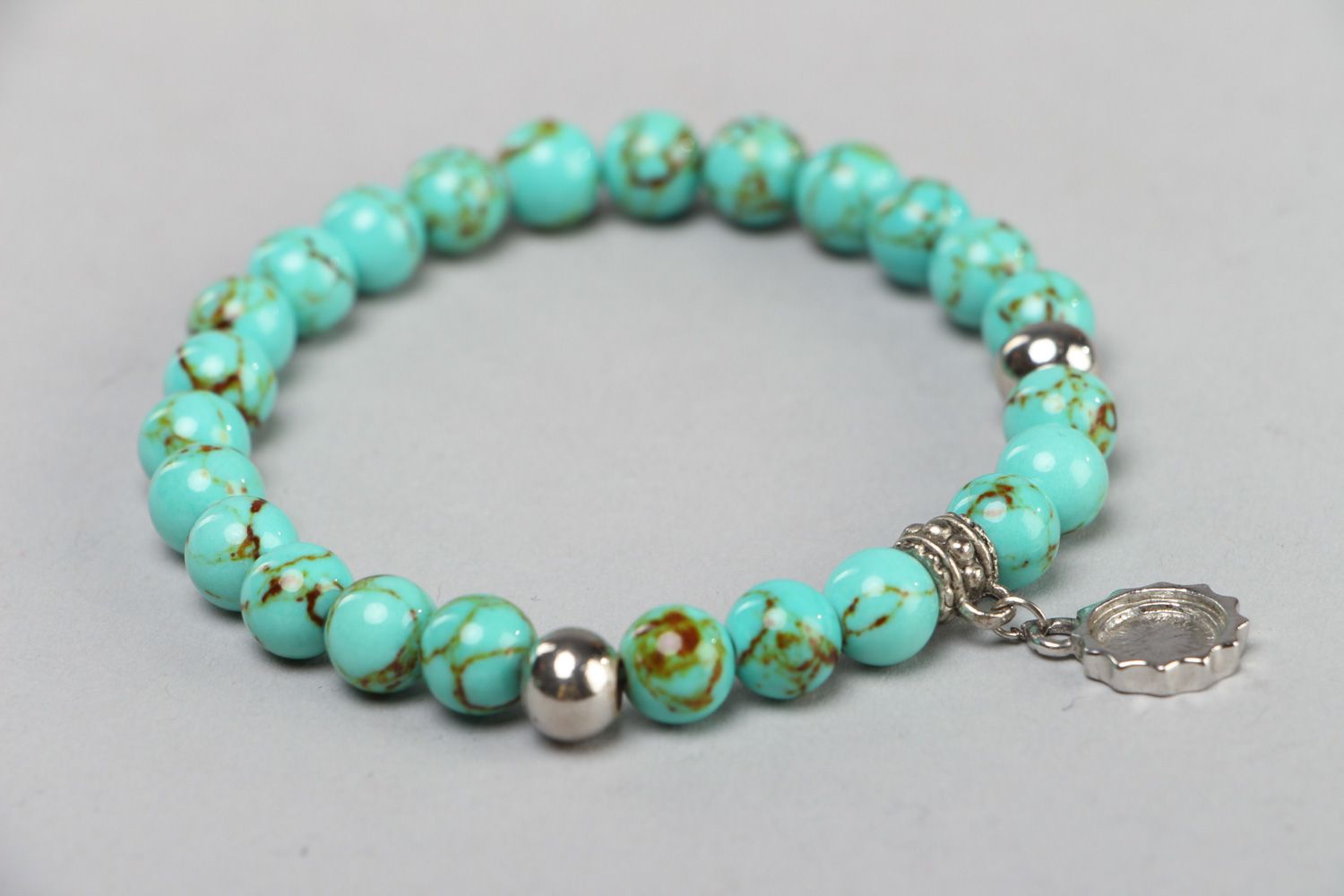 Handmade stretch wrist bracelet with natural turquoise beads and metal charm photo 1