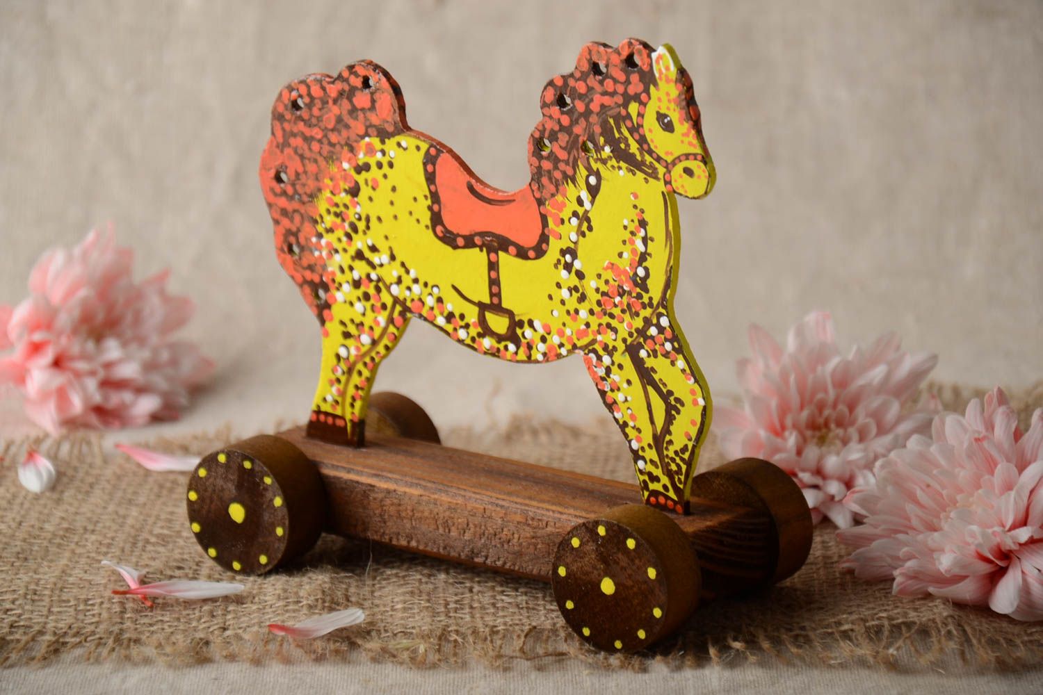 Juguete de madera artesanal con forma de caballo amarillo con ruedas foto 1