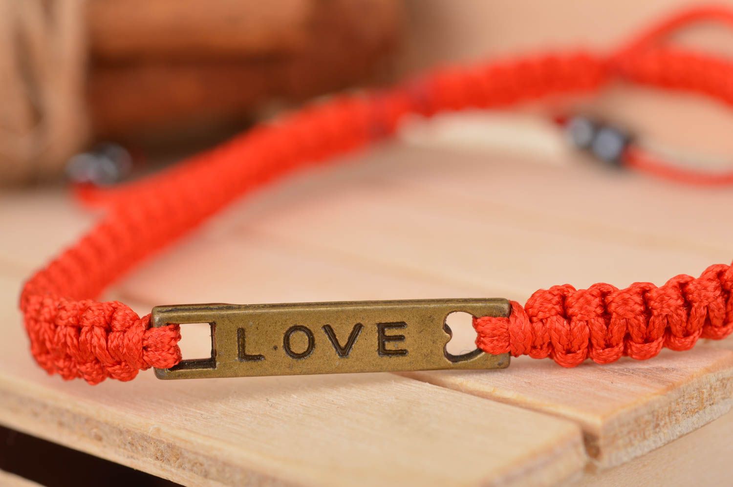 Bracelet fait main rouge en fils de soie avec avec élément métallique Love photo 1