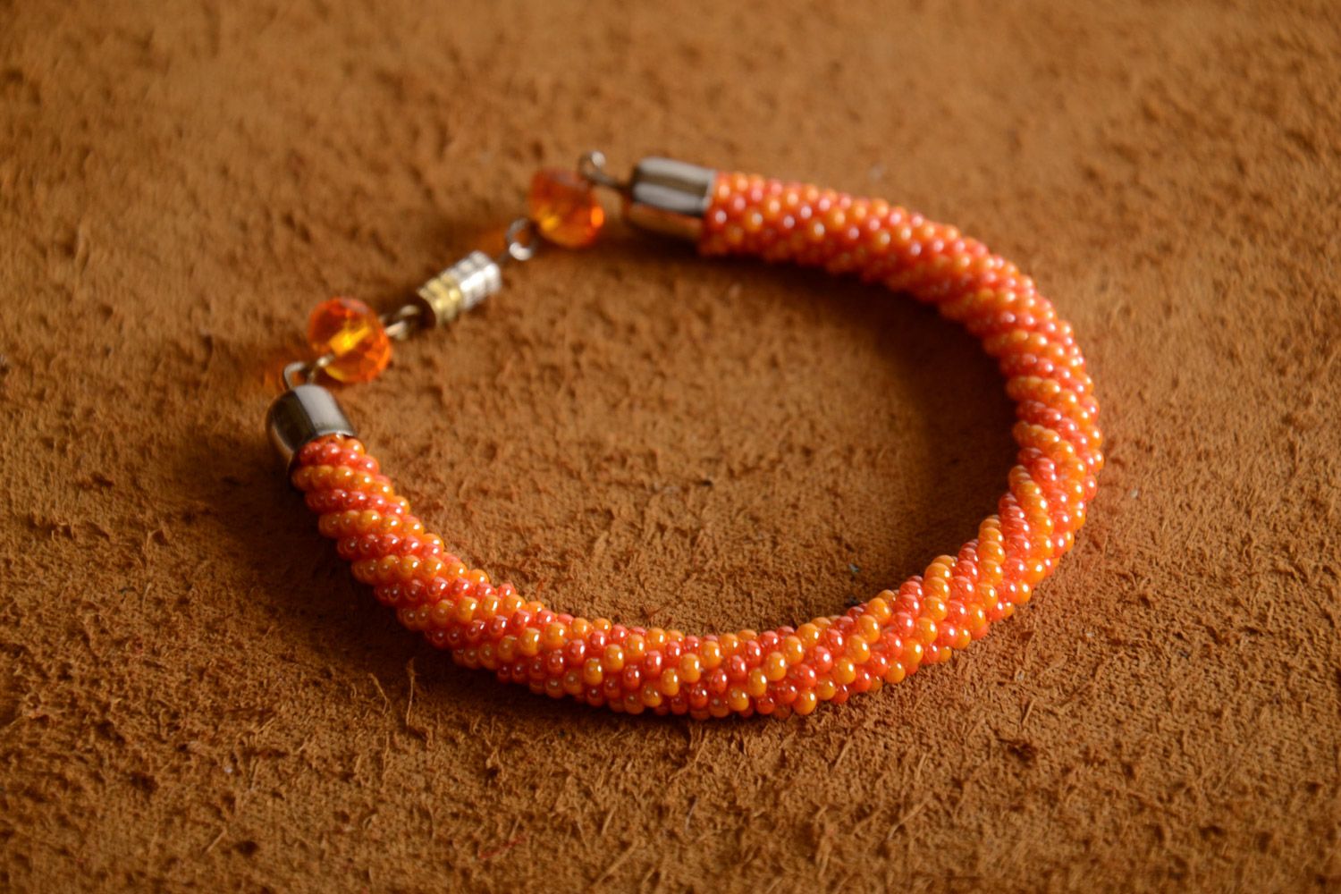 Handmade female bright beautiful designer beaded cord bracelet in orange color photo 1