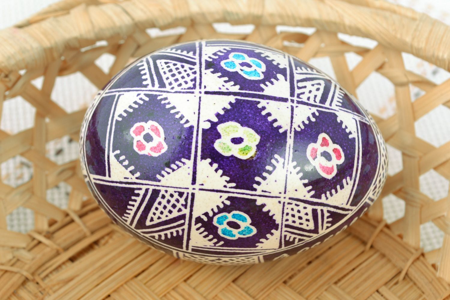 Handmade Easter egg with floral ornament painted with wax in violet color palette photo 1