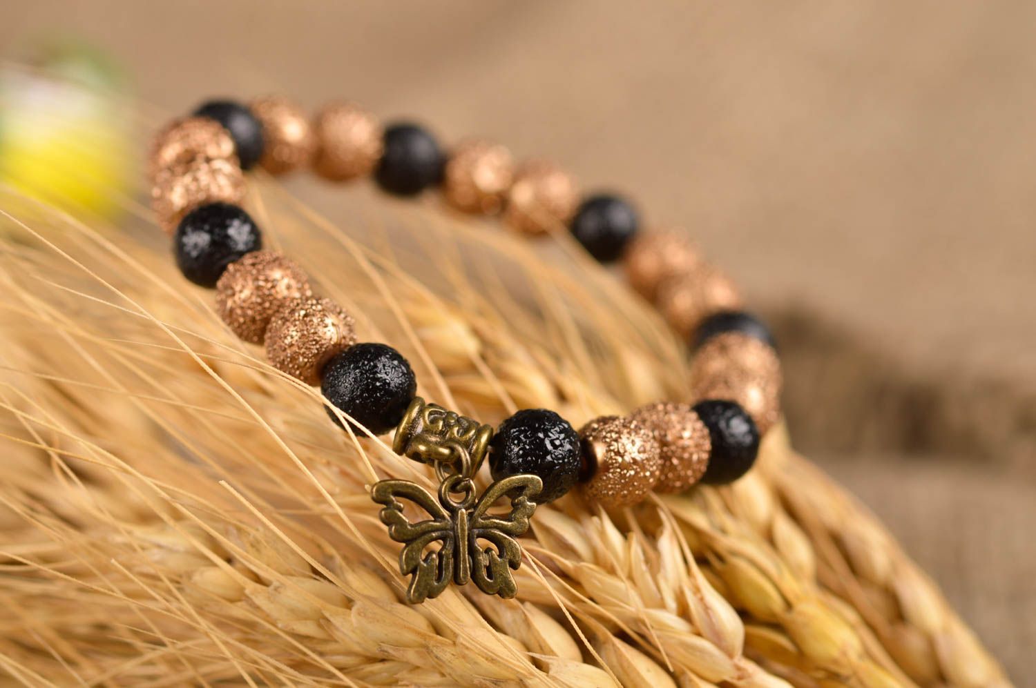 Elastic handmade black and gold color beads bracelet with butterfly charm photo 1