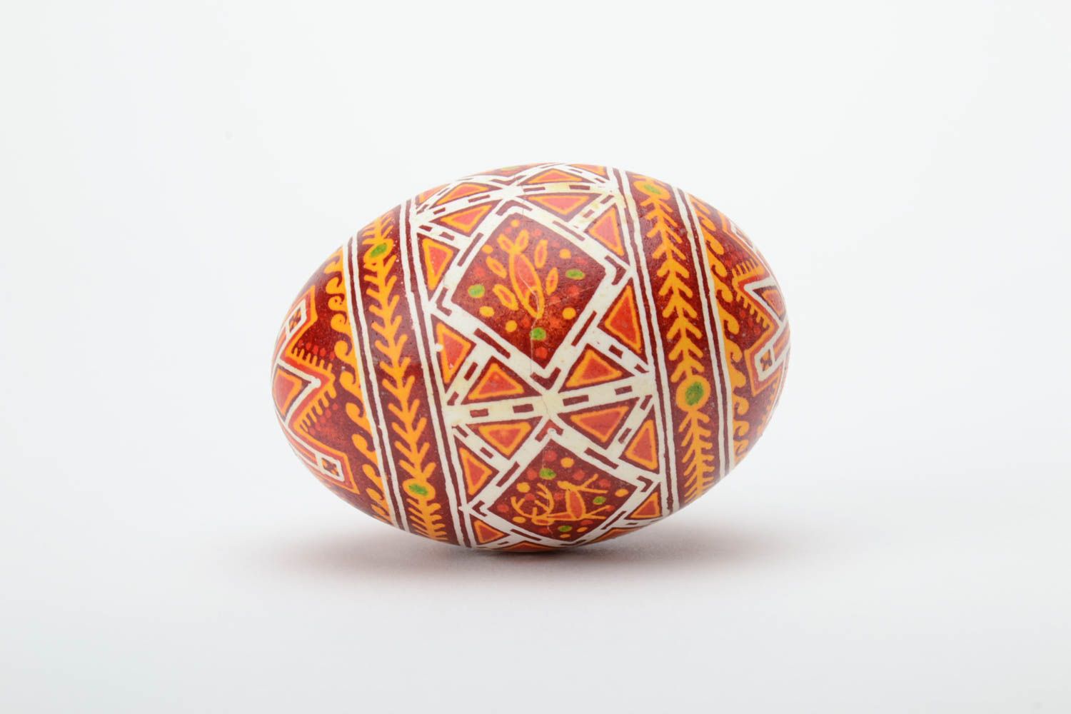 Handmade decorative yellow and red Easter egg painted with wax with deer image photo 3
