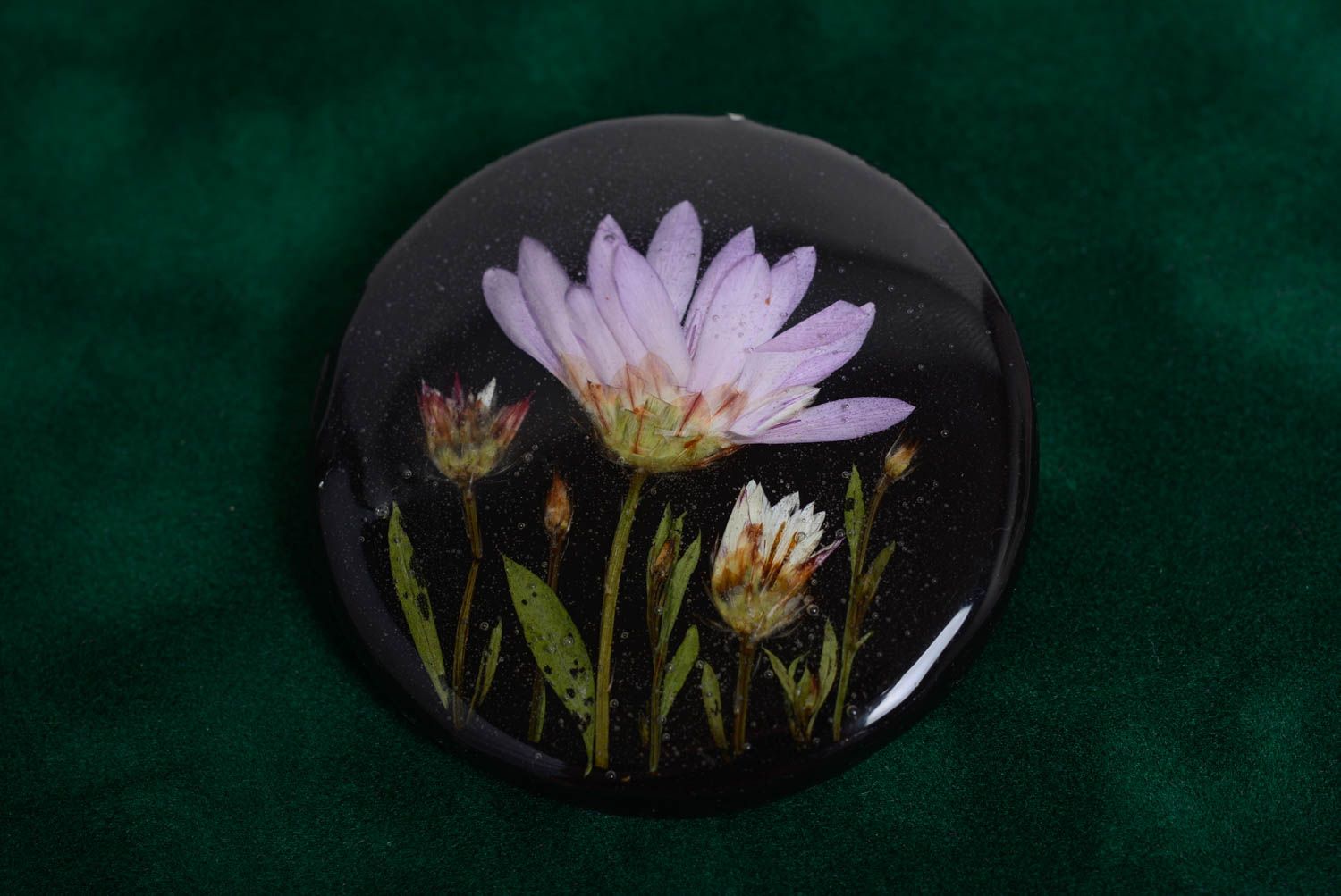 Künstlerische handgemachte Brosche mit Blumen in Epoxidharz rund dunkel handmade foto 3