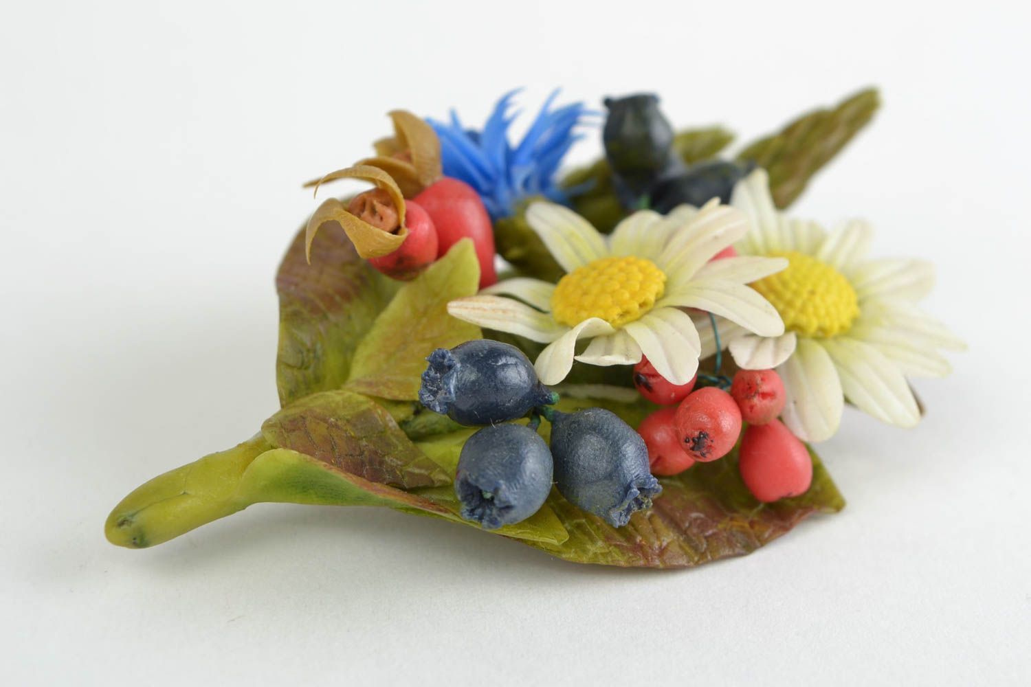 Broche artesanal con flores de porcelana fría con manzanillas bayas y acianos  foto 4
