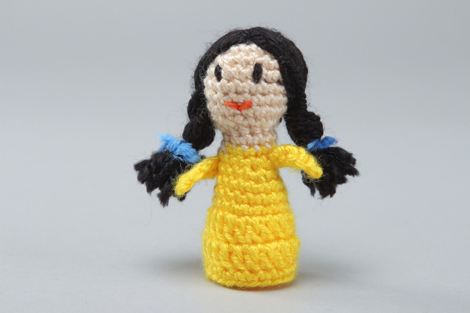 Handmade finger puppet crocheted of acrylic threads girl in yellow dress photo 1