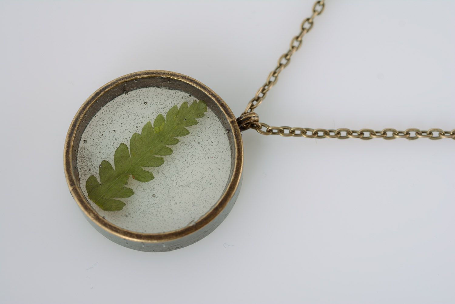 Small round transparent pendant with natural green leaf in epoxy resin on chain photo 5