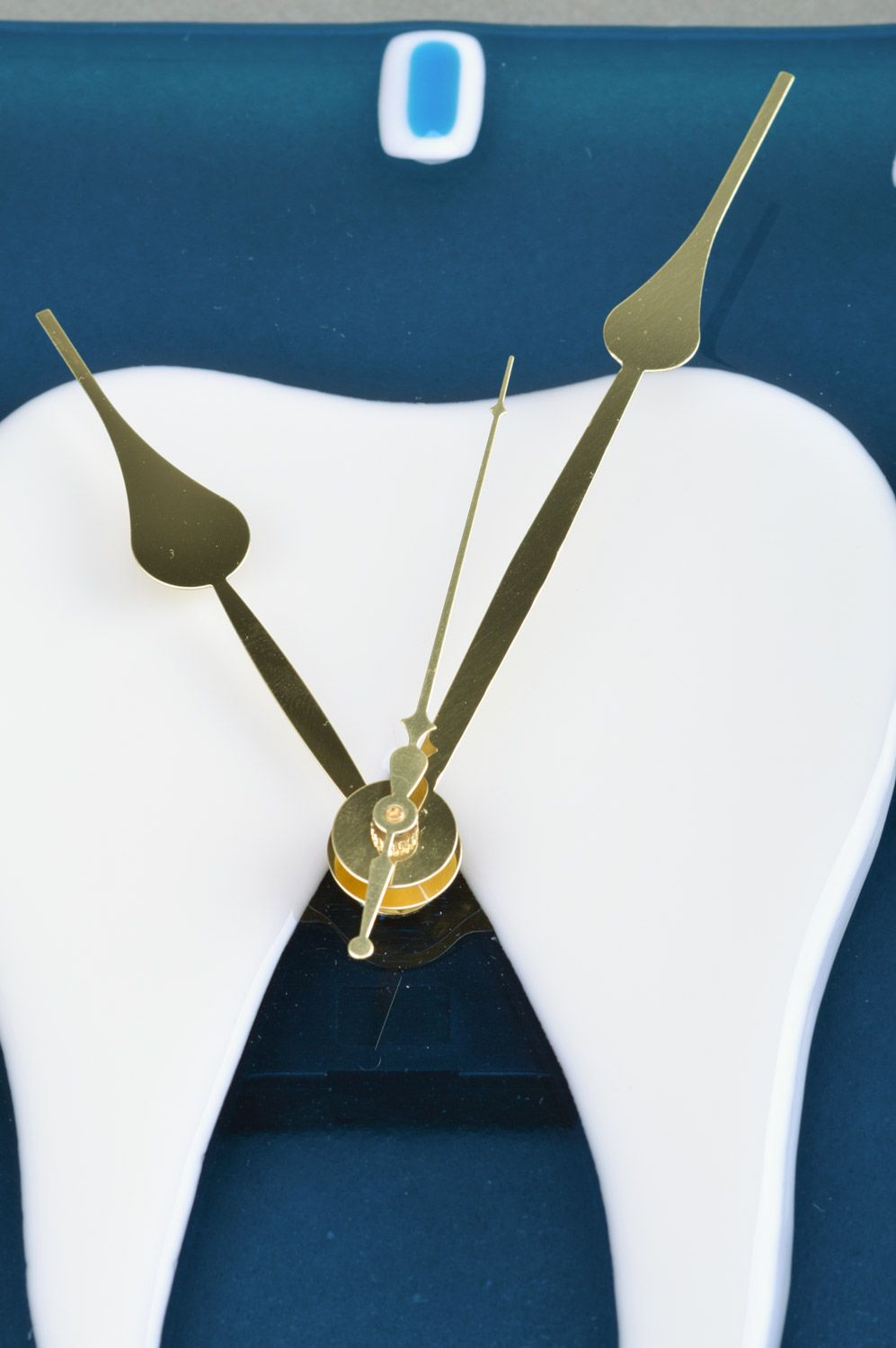Reloj de cristal en técnica de vitrofusión artesanal diente en fondo azul para estomatología foto 3