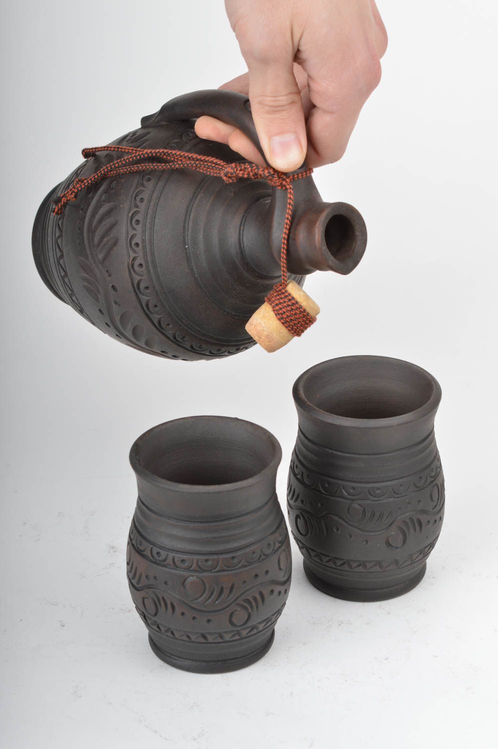 Set of dark brown ceramic drinkware pottery of wine bottle and two wine cups with rustic pattern photo 3