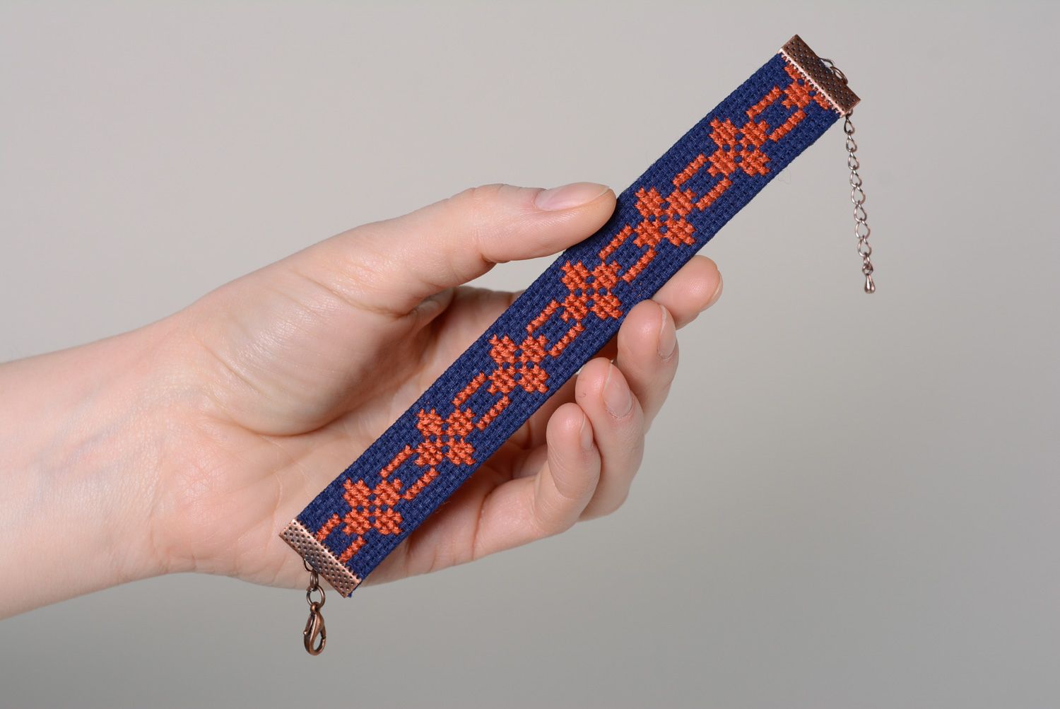Handmade women's wrist bracelet with ethnic embroidery on dark blue background photo 4