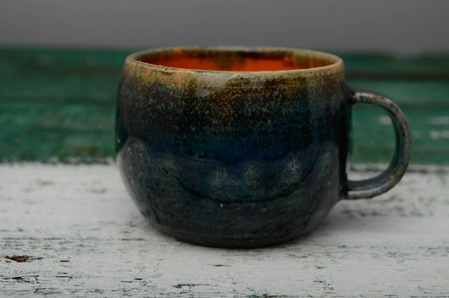 Glazed ceramic handmade coffee cup in deep blue and orange color with handle photo 3