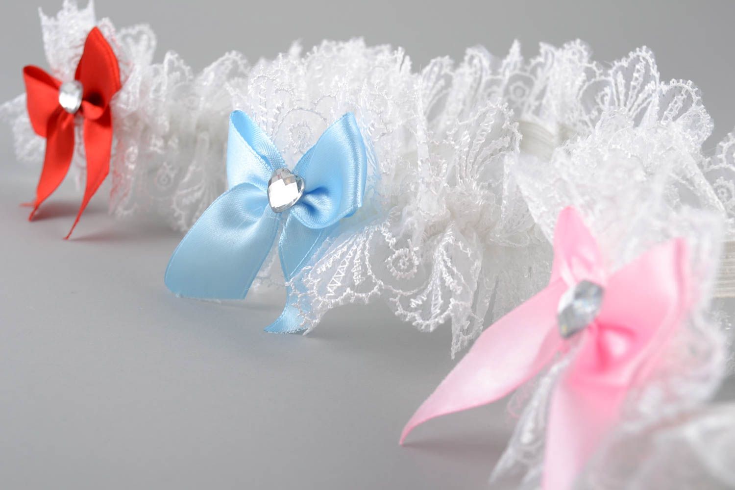 Handmade set of garters 3 pieces made of guipure and satin with colorful bows photo 2