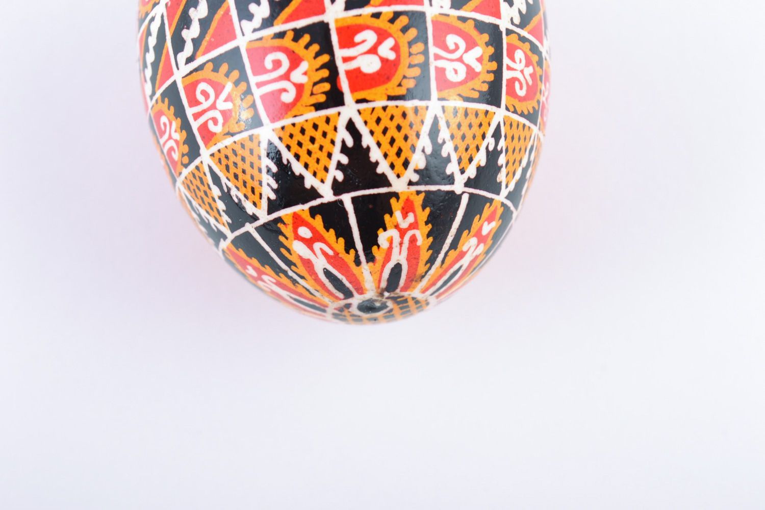 Яркое расписное куриное яйцо ручной работы с узорами на черном фоне фото 3