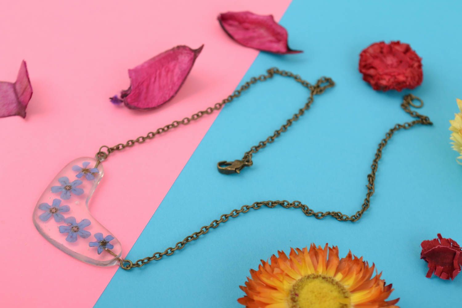 Tender handmade transparent epoxy resin pendant with blue flowers on metal chain photo 1