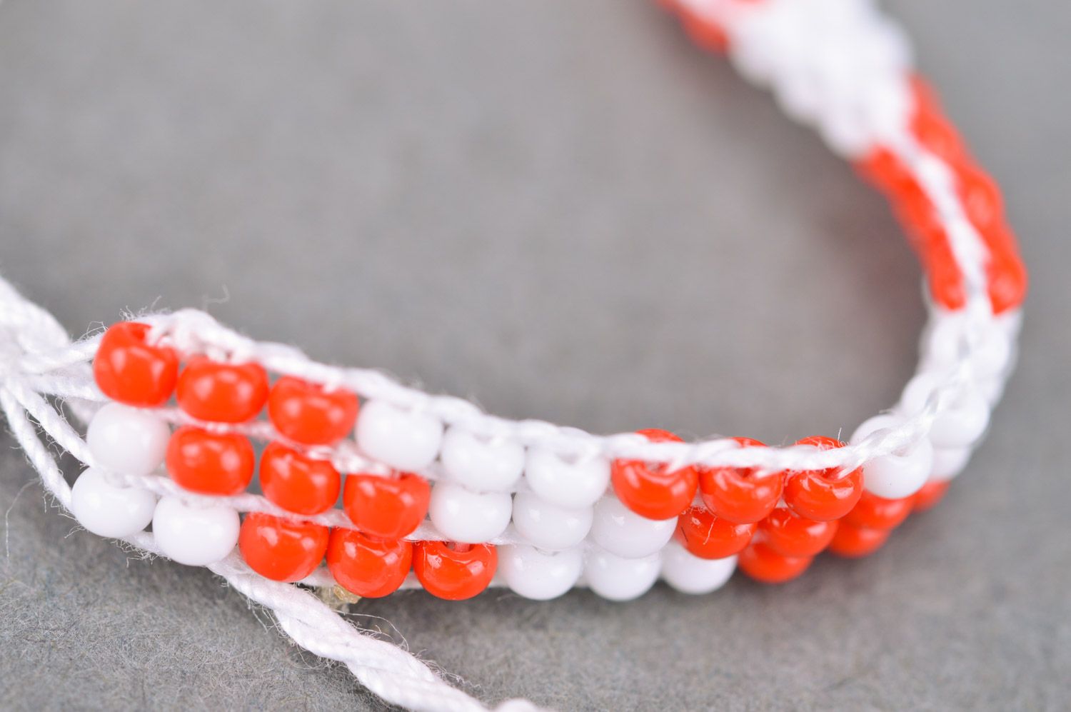Плетеный браслет на руку из бисера ручной работы красный с белым тонкий фото 4