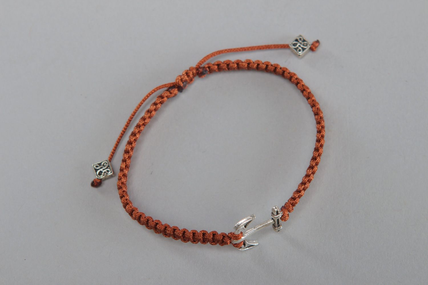Handmade wrist friendship bracelet woven of cord of brown color with anchor  photo 1