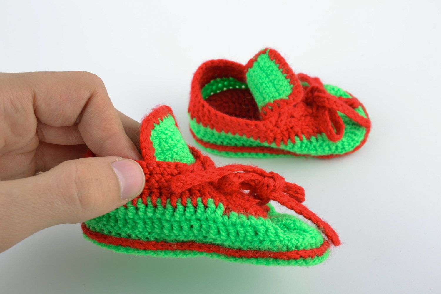 Red and green handmade knitted warm baby booties in the shape of shoes photo 2