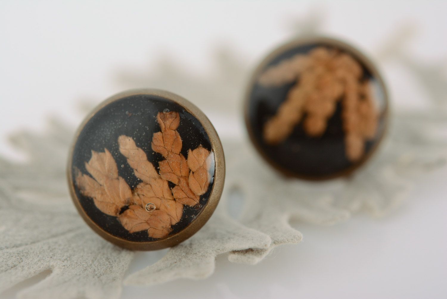 Small round homemade black stud earrings with dried flower in epoxy resin photo 1