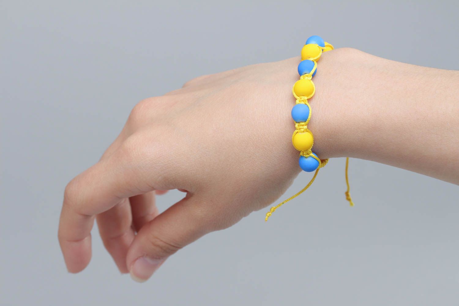Плетеный браслет из ниток с пластиковыми бусинами ручной работы голубой с желтым фото 6